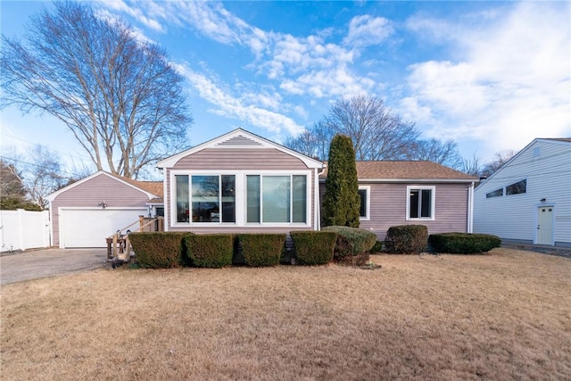 ranch-style home featuring an outbuilding, a garage, and a front lawn