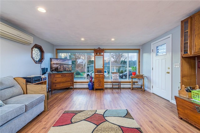 living room with a wall mounted air conditioner and light wood-type flooring