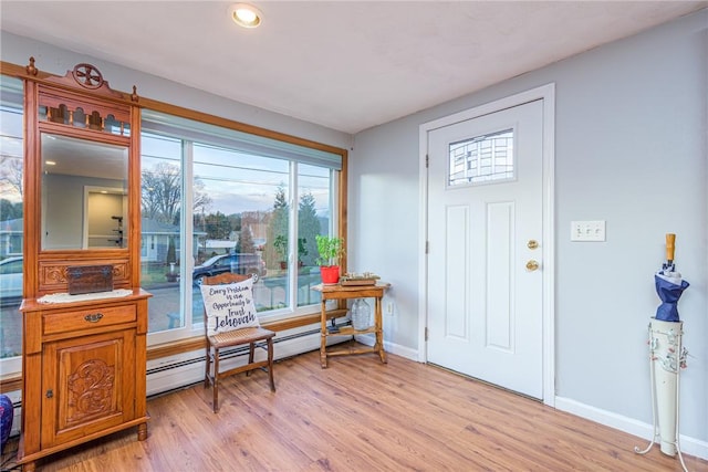 foyer with a baseboard radiator and light hardwood / wood-style floors