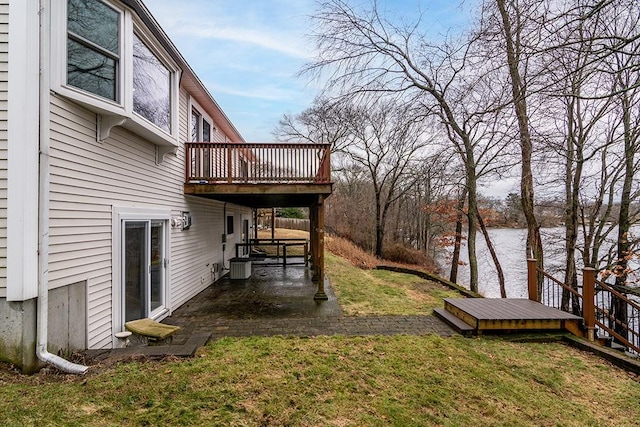 view of yard with a deck with water view, a patio, and central AC unit