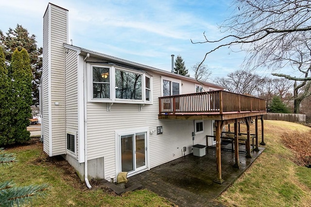 rear view of house with a lawn, a patio area, and a deck