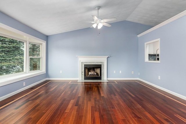 unfurnished living room with ceiling fan, a high end fireplace, hardwood / wood-style floors, lofted ceiling, and ornamental molding