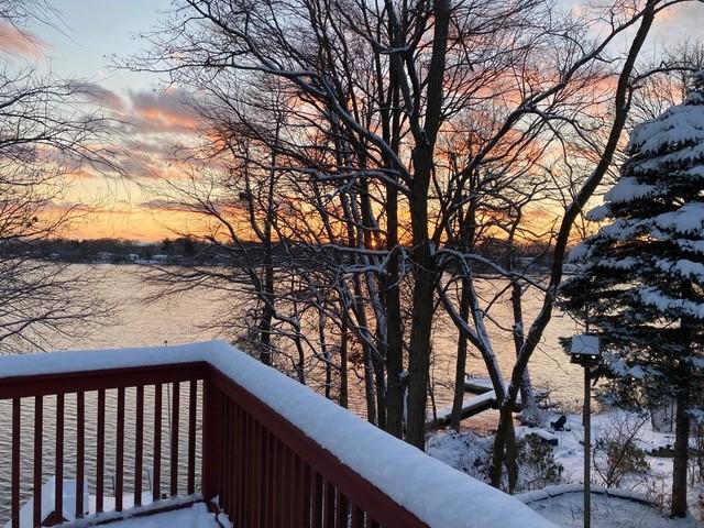 view of snow covered back of property