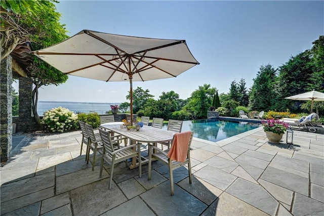 outdoor pool with outdoor dining area and a patio area