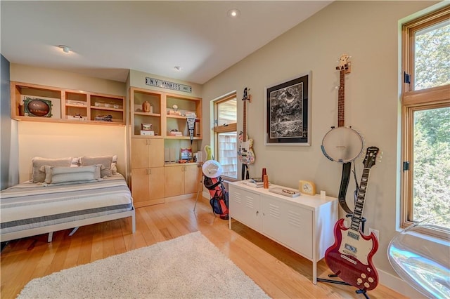 bedroom with light wood finished floors and multiple windows