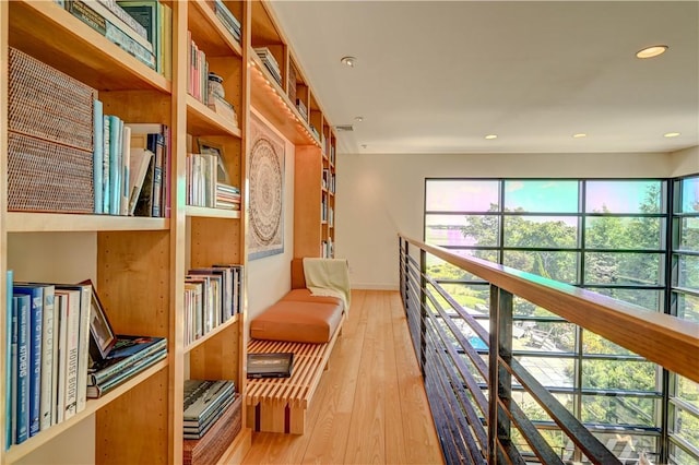 living area featuring an upstairs landing, wood-type flooring, baseboards, and recessed lighting