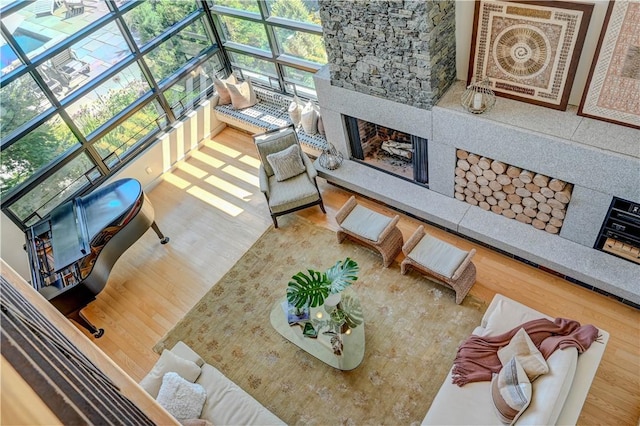 living area with a fireplace, wood finished floors, and a sunroom