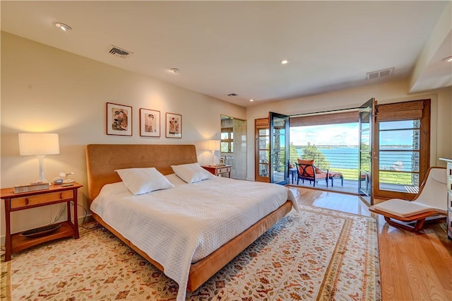 bedroom with access to exterior, recessed lighting, visible vents, and wood finished floors