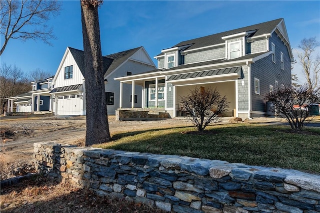 view of front of house featuring a porch, a garage, and a front yard