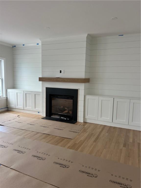 15 Cora St, East Greenwich, RI 02818 - detailed view of wood finished floors, crown molding, a fireplace, and wood walls