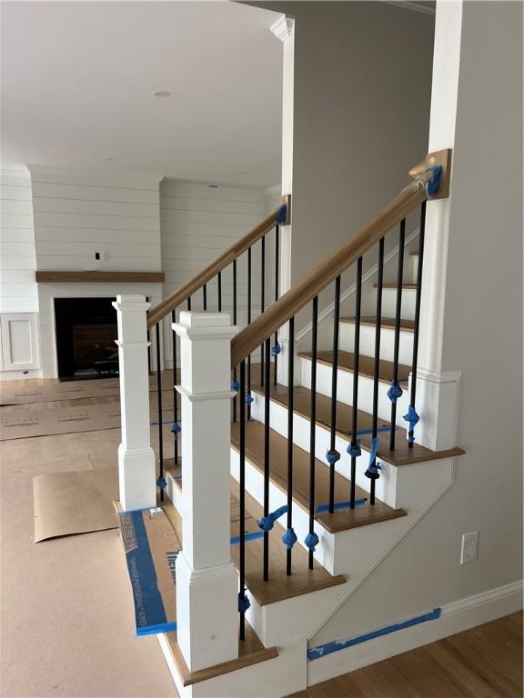 15 Cora St, East Greenwich, RI 02818 - stairway with baseboards, wood finished floors, and a fireplace
