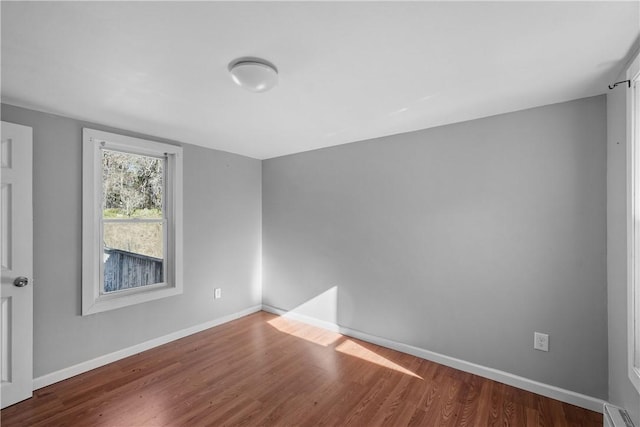 spare room with hardwood / wood-style floors and baseboard heating