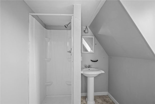 bathroom featuring vaulted ceiling and walk in shower