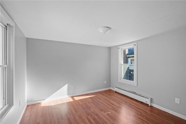 spare room with hardwood / wood-style floors and baseboard heating