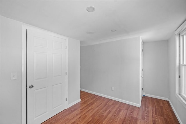 unfurnished bedroom featuring multiple windows and hardwood / wood-style flooring