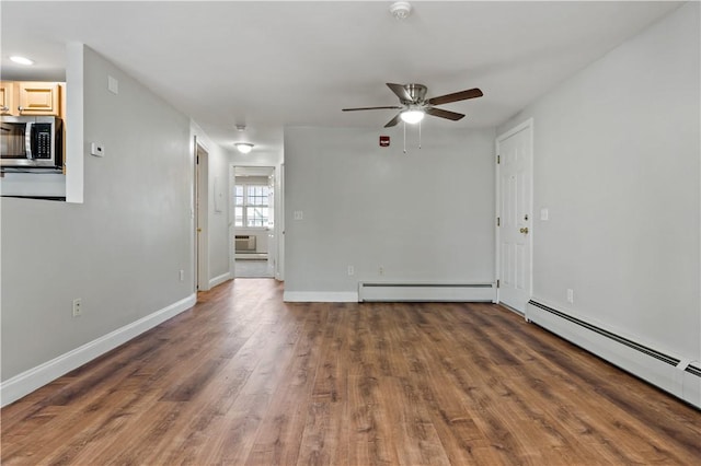 unfurnished room with a baseboard radiator, ceiling fan, and dark wood-type flooring