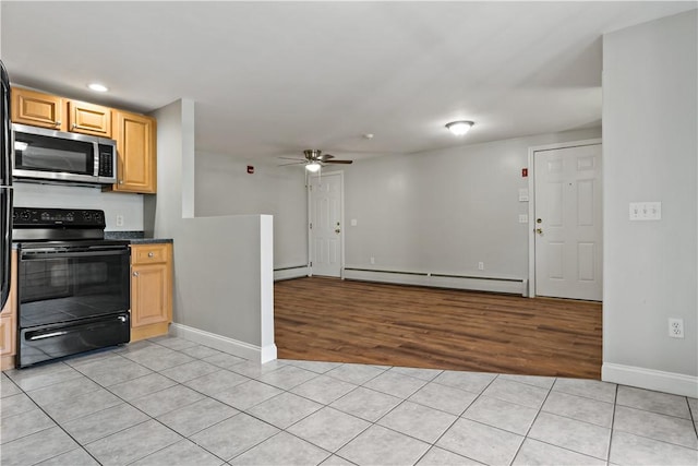 kitchen featuring ceiling fan, baseboard heating, black electric range oven, light brown cabinetry, and light tile patterned flooring