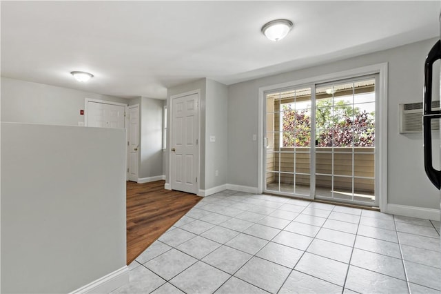 empty room with an AC wall unit and light tile patterned flooring