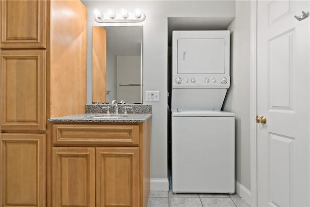 laundry room with light tile patterned floors, stacked washer / drying machine, and sink