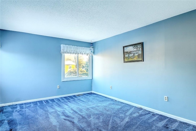 carpeted empty room featuring a textured ceiling