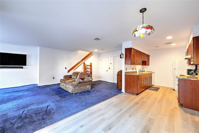 living room featuring sink and light hardwood / wood-style floors