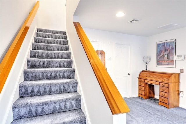 staircase featuring carpet