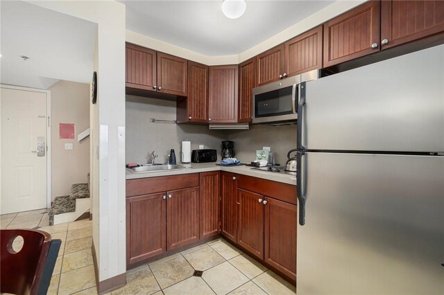 kitchen featuring sink, light tile patterned floors, and stainless steel appliances