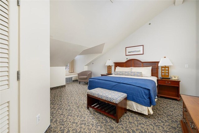 bedroom featuring dark carpet and vaulted ceiling