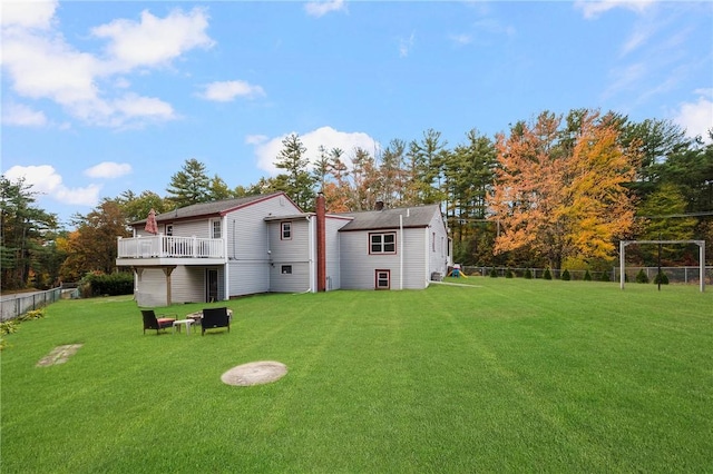 rear view of property with a deck and a yard