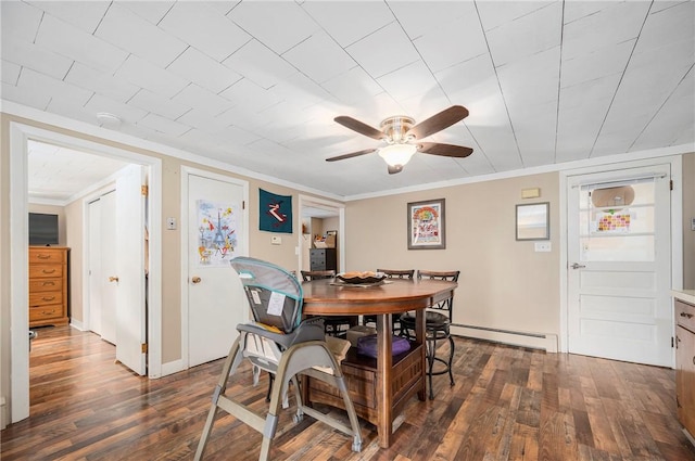 dining space with ceiling fan, dark hardwood / wood-style flooring, ornamental molding, and baseboard heating