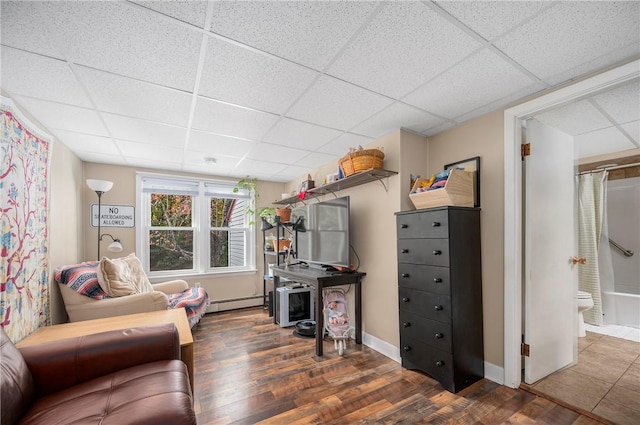 home office with a paneled ceiling, dark hardwood / wood-style floors, and a baseboard radiator