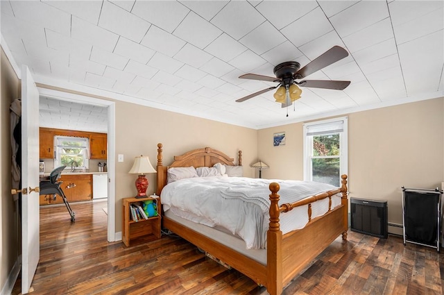 bedroom with ceiling fan, crown molding, dark wood-type flooring, and a baseboard radiator