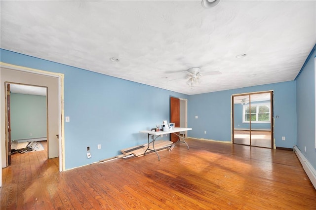 empty room featuring baseboard heating, ceiling fan, and light hardwood / wood-style flooring