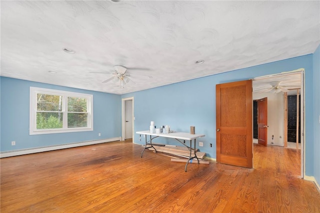 unfurnished room featuring light hardwood / wood-style flooring and a baseboard heating unit