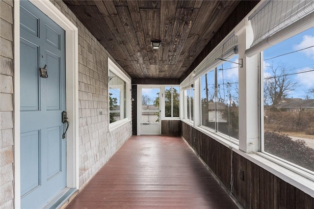 unfurnished sunroom featuring a wealth of natural light and wooden ceiling