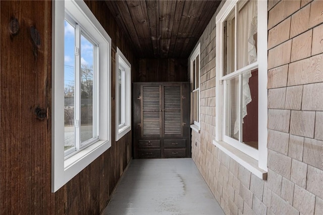 unfurnished sunroom featuring a wealth of natural light and wooden ceiling