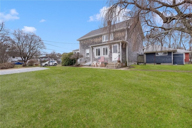 rear view of house featuring a lawn