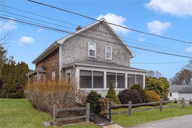 view of front of property with a sunroom and a front lawn