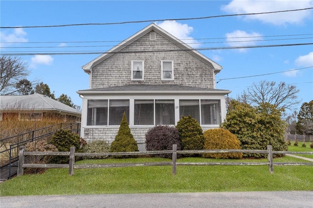 view of property with a sunroom and a front yard