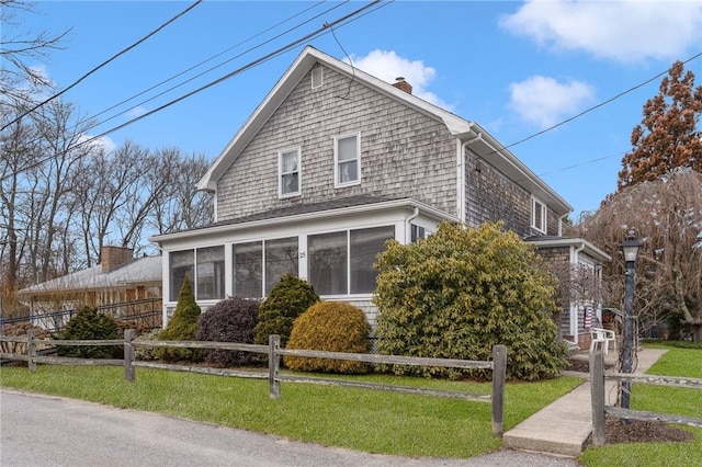 view of front of property with a sunroom and a front yard