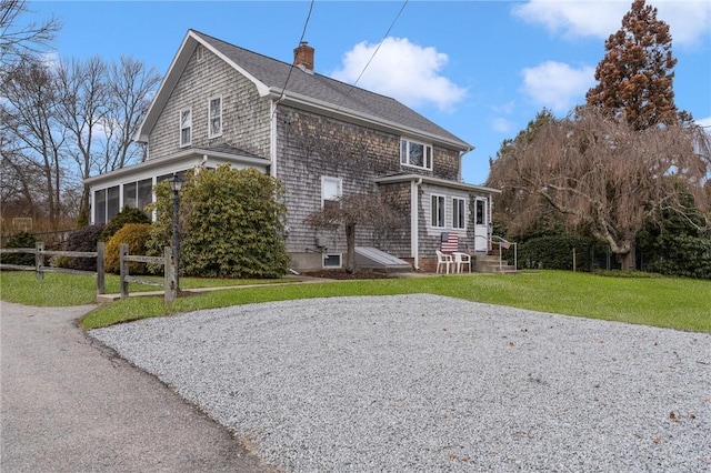 view of side of home with a lawn and a sunroom