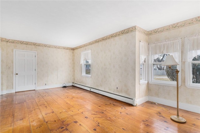 unfurnished room featuring hardwood / wood-style floors and baseboard heating