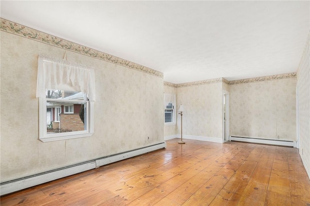 spare room with wood-type flooring and a baseboard radiator