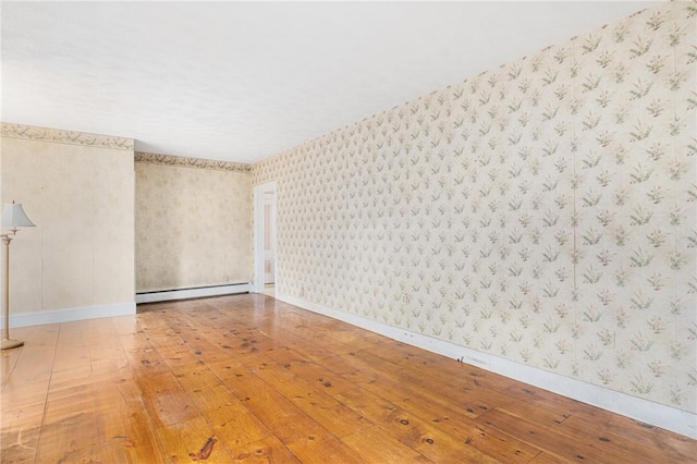 spare room with wood-type flooring and a baseboard radiator