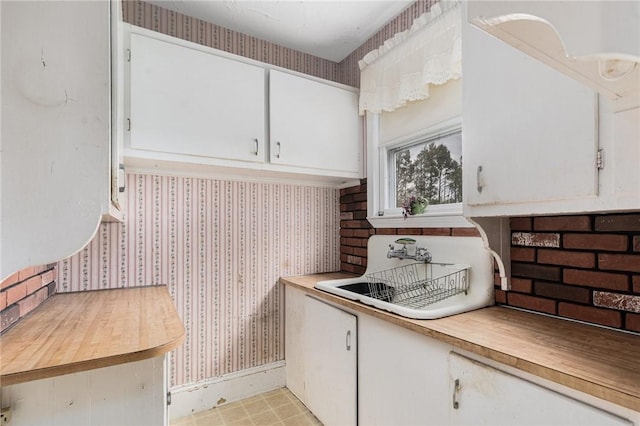 kitchen featuring white cabinets and sink