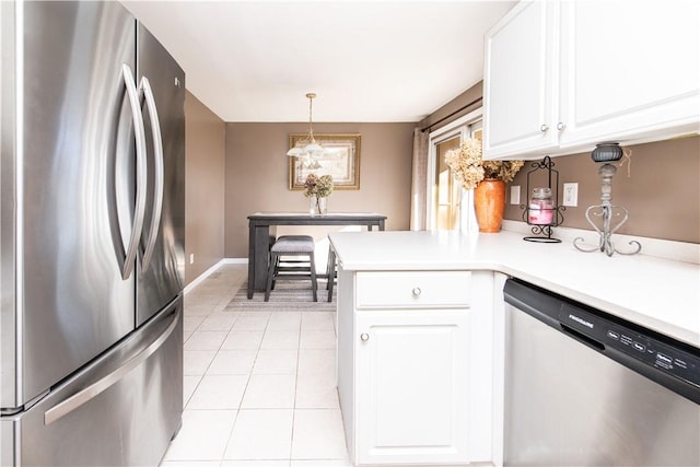 kitchen featuring pendant lighting, white cabinets, light tile patterned floors, kitchen peninsula, and stainless steel appliances