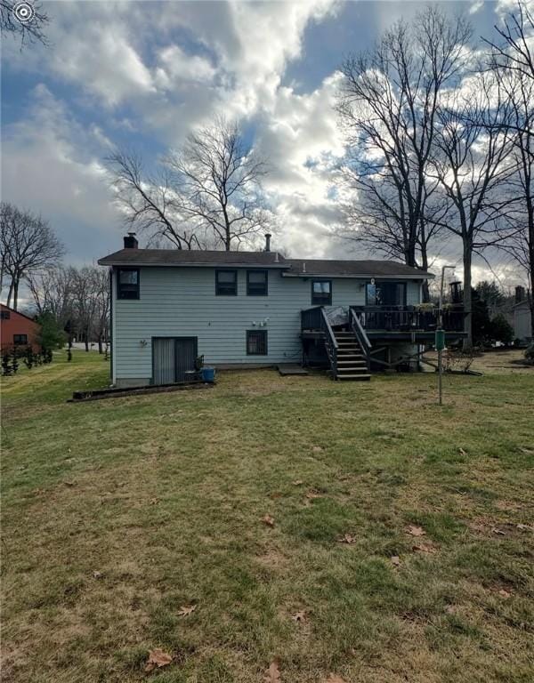 rear view of house featuring a deck and a lawn