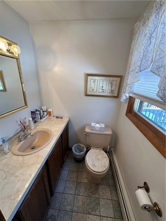 bathroom with vanity, toilet, and baseboard heating