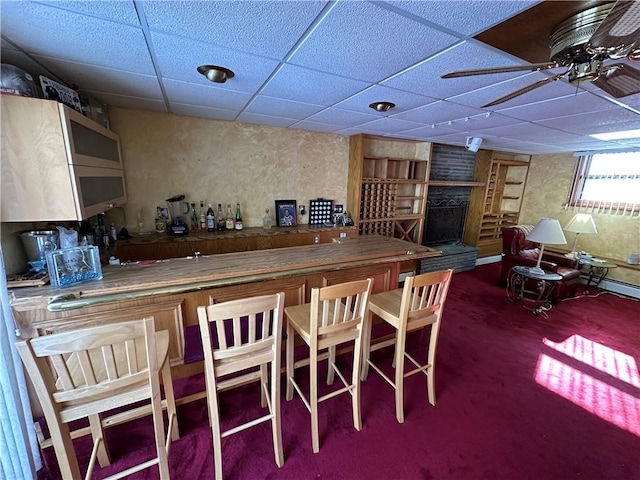 bar with carpet floors, a paneled ceiling, and ceiling fan