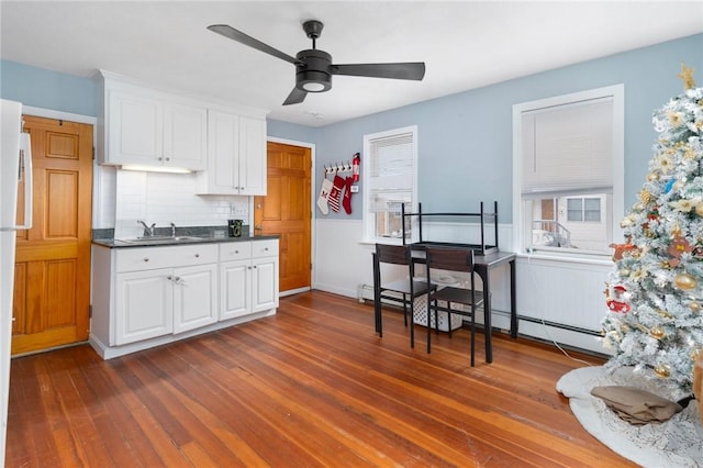 kitchen with decorative backsplash, ceiling fan, sink, white cabinets, and dark hardwood / wood-style floors